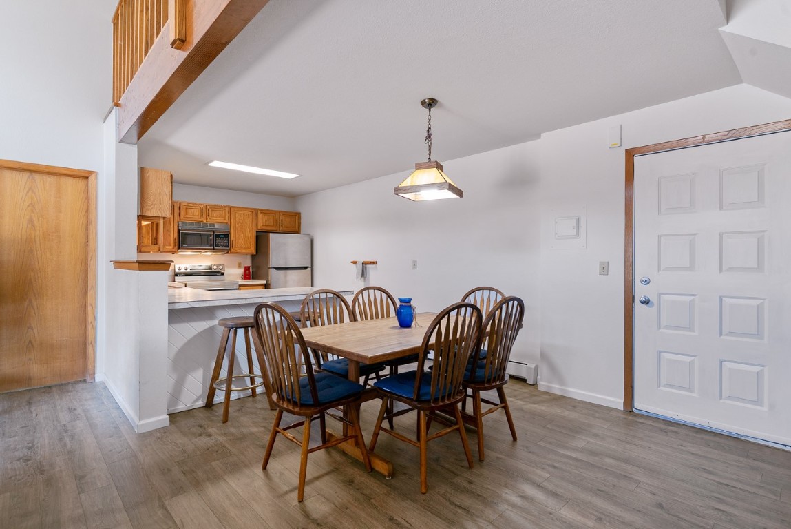 89310 Ryan Gulch Road, Unit 409 Silverthorne, CO 80498 - Photo 4 of 21 a view of a dining room with furniture and wooden floor