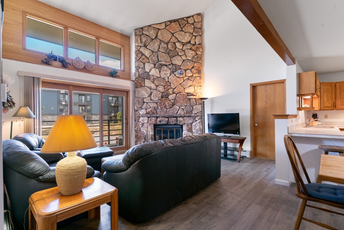 89310 Ryan Gulch Road, Unit 409 Silverthorne, CO 80498 - Photo 6 of 21 a living room with furniture a fireplace and a flat screen tv