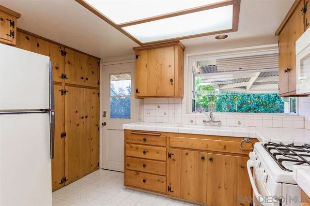 a kitchen with cabinets a window and a refrigerator