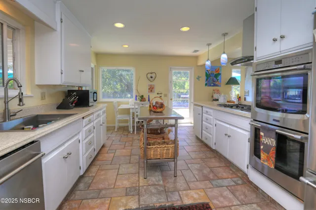 a kitchen with stainless steel appliances granite countertop a stove top oven a sink dishwasher and a refrigerator