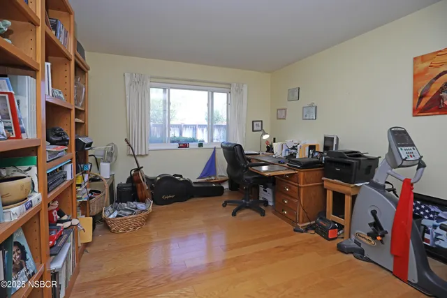 a view of a workspace with furniture and a window