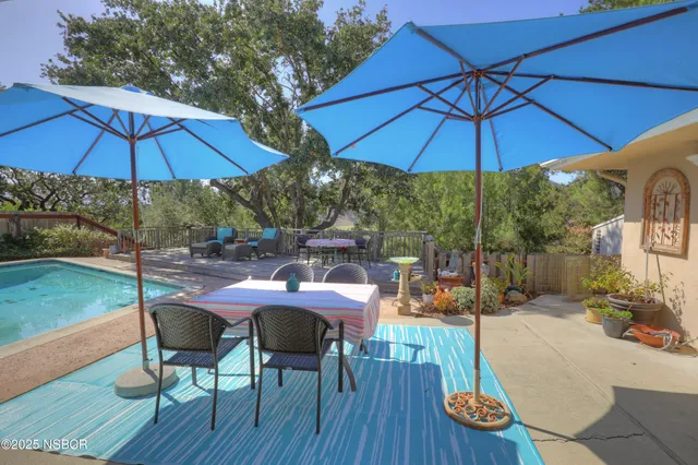 a patio with wooden table and umbrella