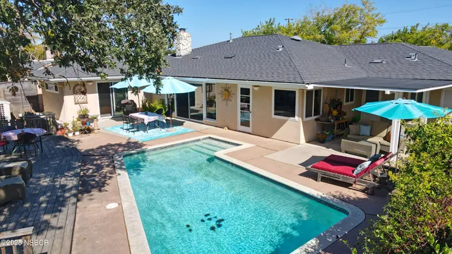a view of a house with backyard and sitting area