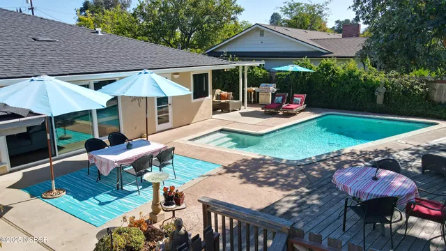 a view of a patio with table and chairs under an umbrella