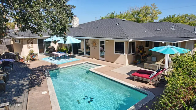 a view of a house with backyard and sitting area