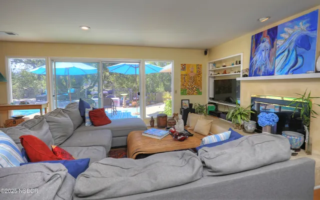 a living room with fireplace furniture and a large window