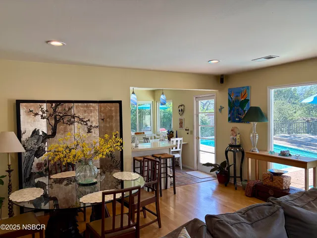 a very nice looking living room with a large window and dining table