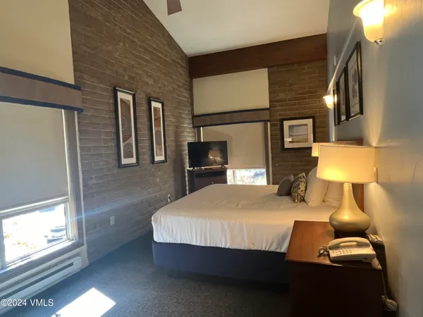a bedroom with a bed and a lamp on table
