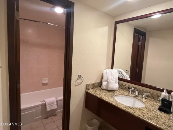 a bathroom with a granite countertop sink a toilet and a mirror