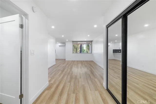 a view of a hallway with wooden floor and a bathroom