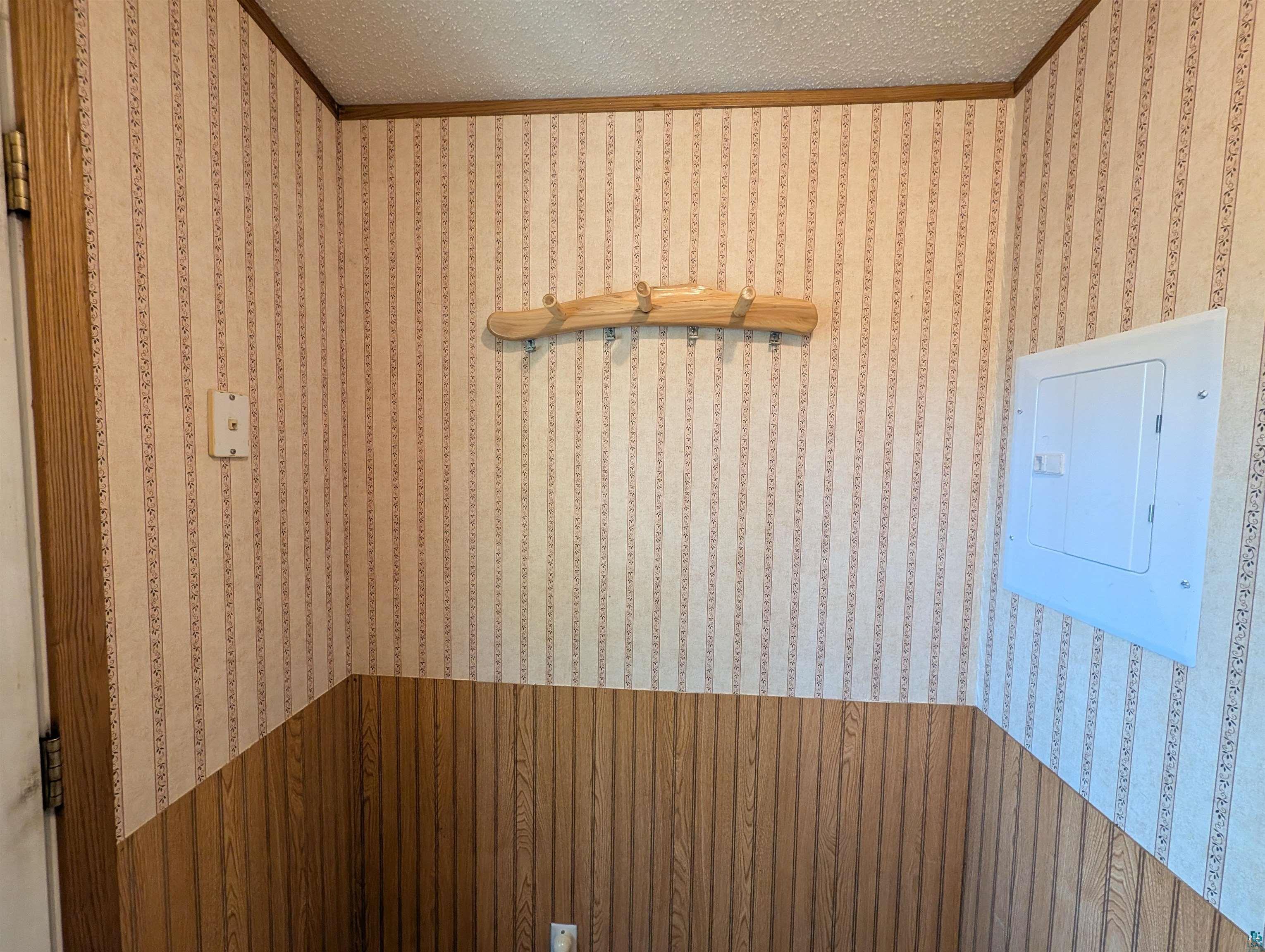 3945 Maple Street Kettle River, MN 55757 - Photo 35 of 41 Corridor area featuring striped wallpaper, wood-finish paneling, and a wood coat rack