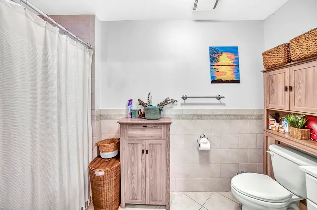 a bathroom with a sink a toilet and shower curtain
