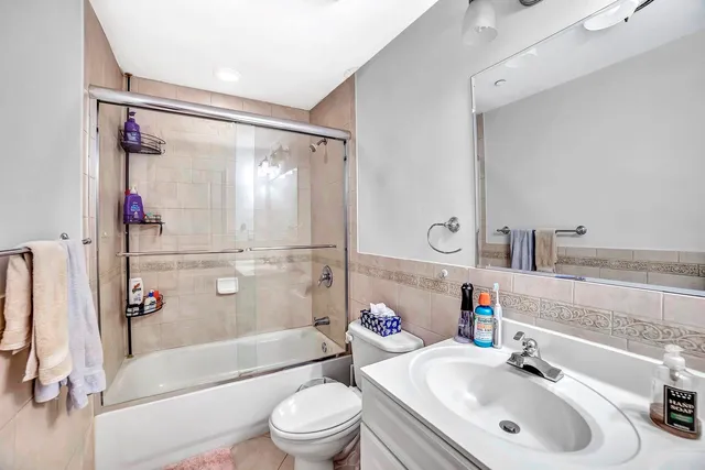 a bathroom with a sink mirror bathtub and toilet