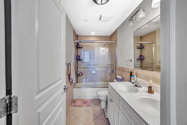 a bathroom with a sink a toilet a mirror and shower