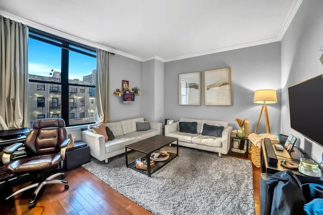 a living room with furniture a flat screen tv and a table