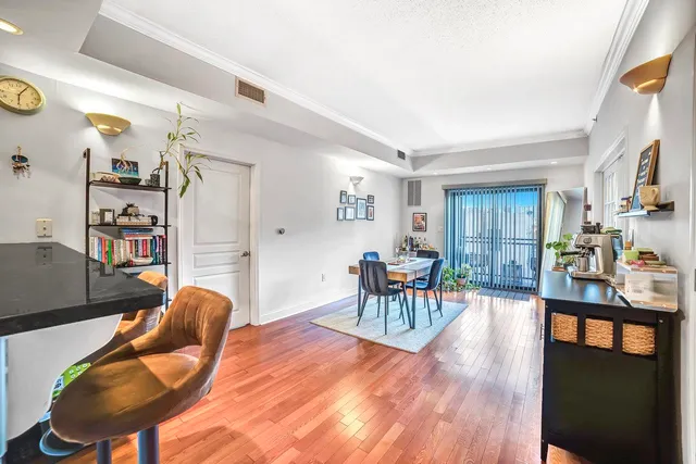a living room with furniture a dining table and wooden floor
