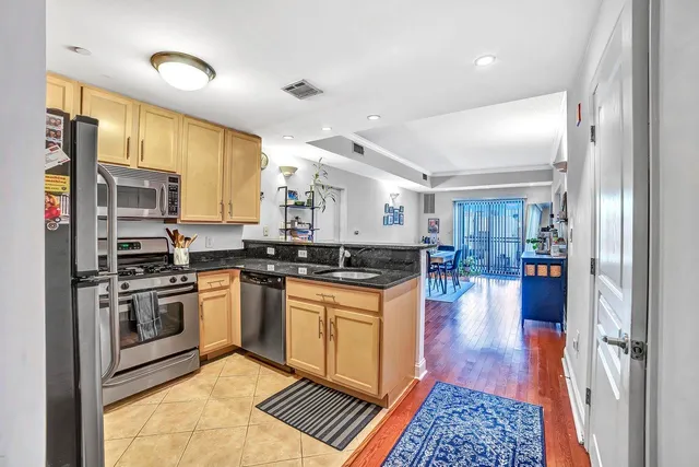 a kitchen with stainless steel appliances granite countertop a refrigerator and a stove top oven