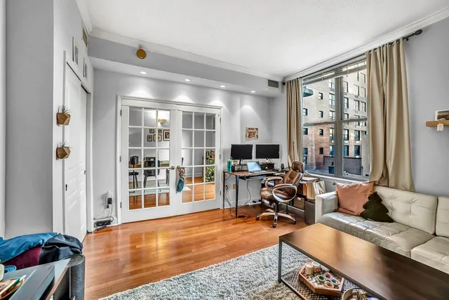 a view of a livingroom with workspace and a window