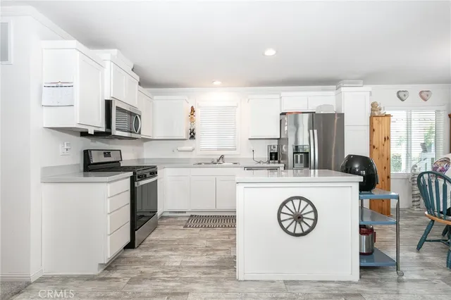 a kitchen with stainless steel appliances granite countertop a refrigerator a stove a sink and a microwave