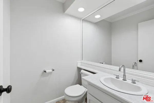 a bathroom with a toilet a sink and mirror