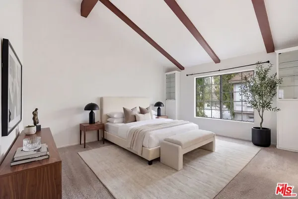 a bedroom with a large bed and a window