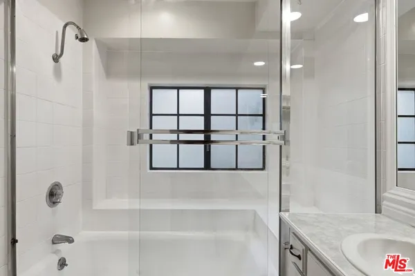 a bathroom with a granite countertop bathtub and a shower