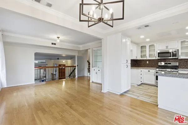 a view of a kitchen with stainless steel appliances granite countertop a refrigerator and a stove top oven