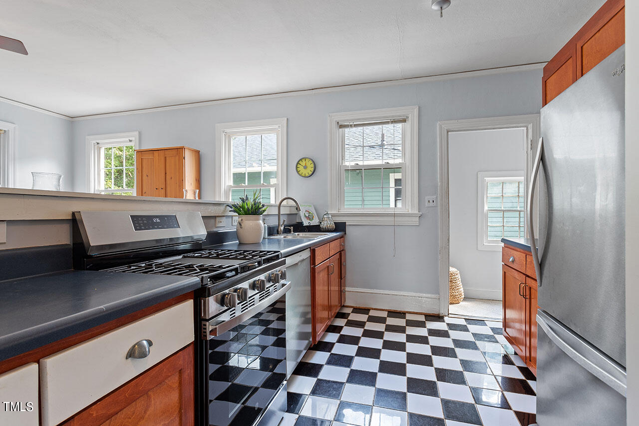 628 East Franklin Street Raleigh, NC 27604 - Photo 21 of 37 a kitchen with stainless steel appliances a stove a sink a refrigerator white cabinets and wooden floor