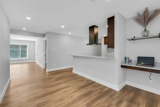 a view of a kitchen with wooden floor and a sink