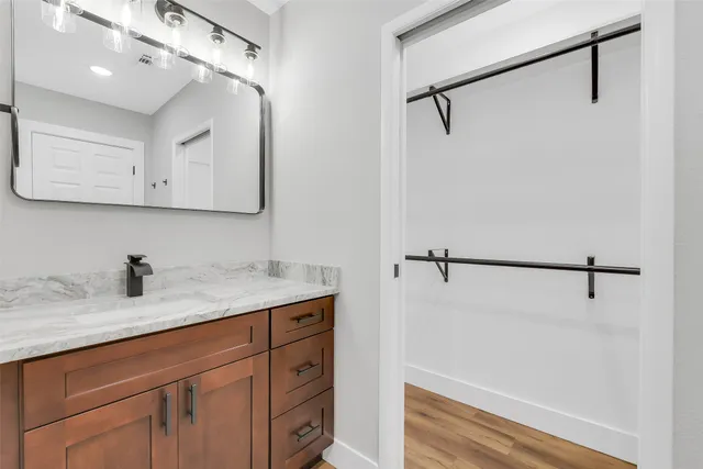 a bathroom with a granite countertop sink vanity and mirror