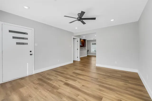 a view of empty room with wooden floor and ceiling fan