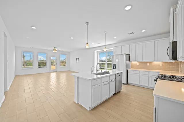 a view of an empty room with a kitchen