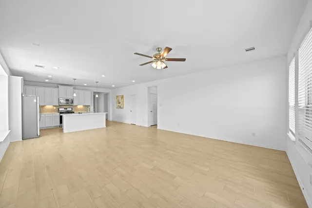 a walk in closet with wooden floor