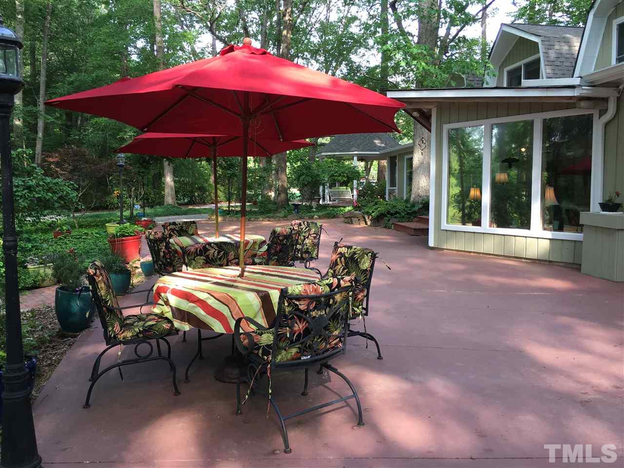 7018 Farmdale Road Raleigh, NC 27610 - Photo 16 of 25 a view of a patio with table and chairs under an umbrella