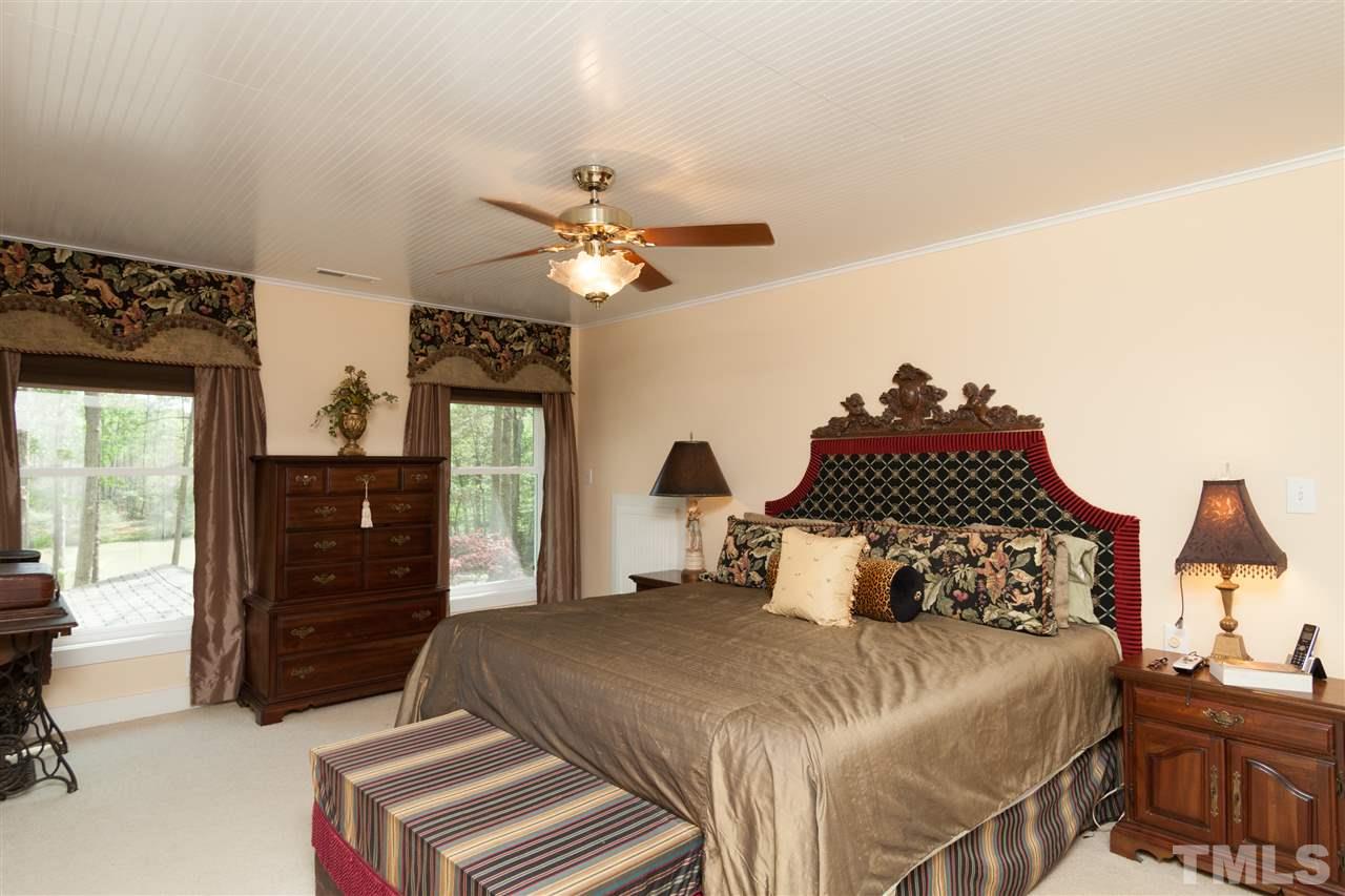 7018 Farmdale Road Raleigh, NC 27610 - Photo 20 of 25 a bedroom with a bed and a chandelier