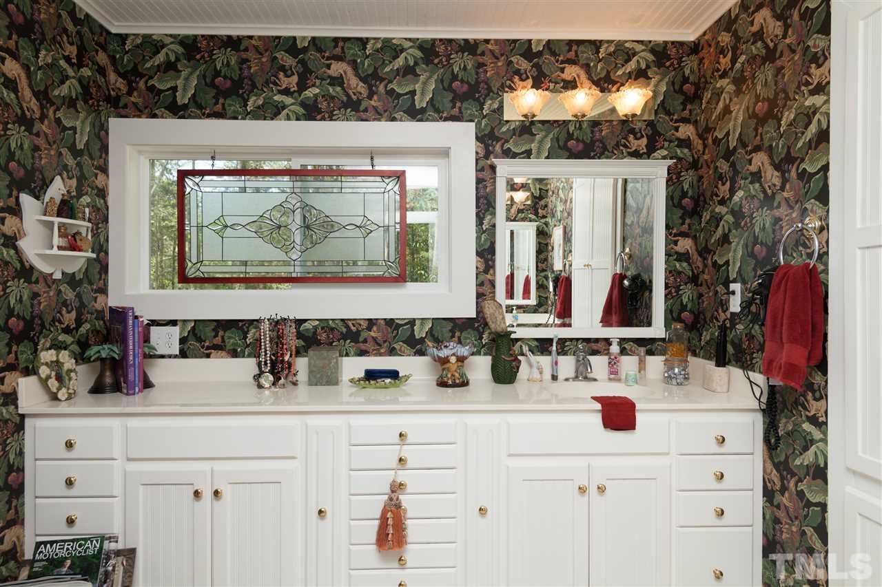 7018 Farmdale Road Raleigh, NC 27610 - Photo 21 of 25 a bathroom with a sink and a mirror