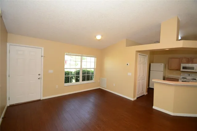 a view of a kitchen with a sink dishwasher oven window and wooden floor