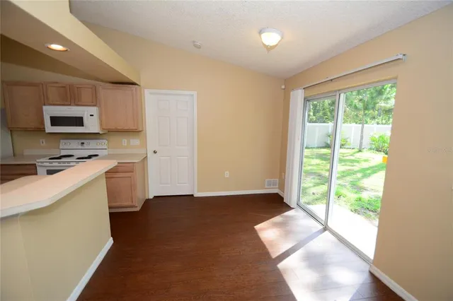 a kitchen with a refrigerator a stove top oven a sink and a window