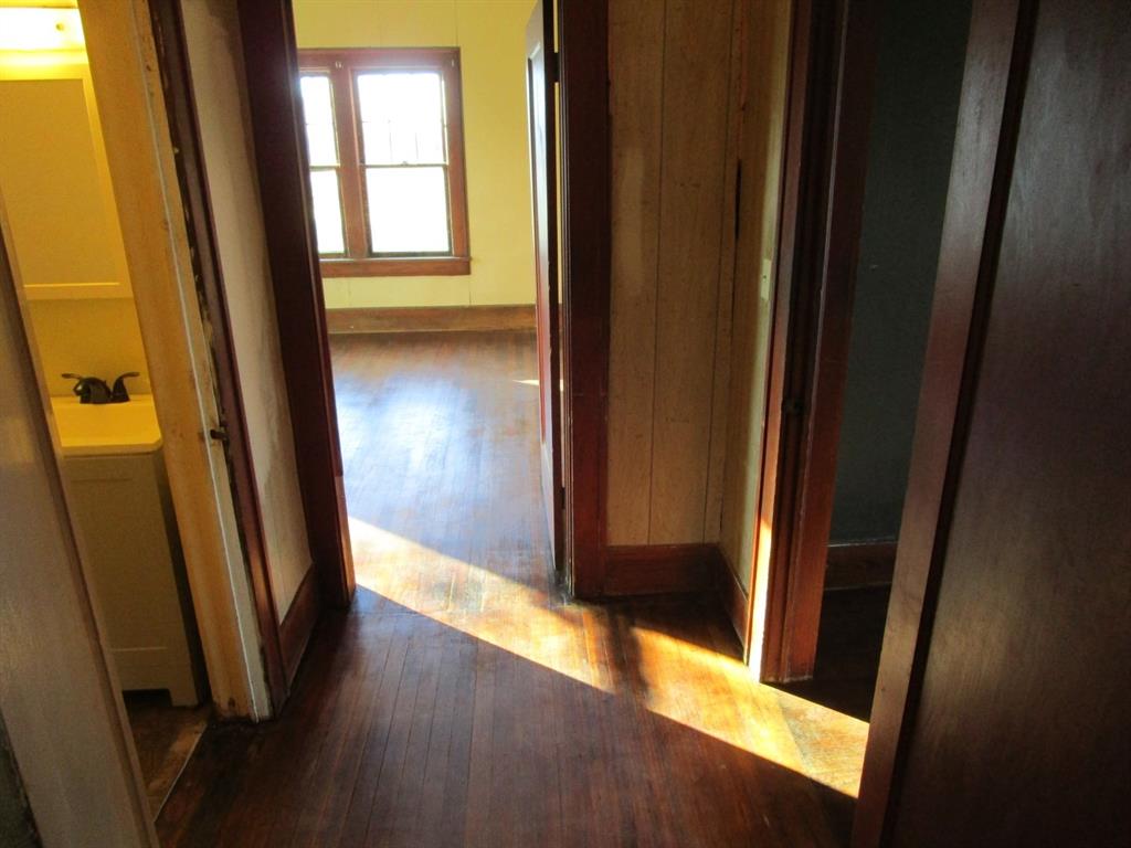 1206 South Main Street Quanah, TX 79252 - Photo 14 of 22 Corridor featuring a sink, baseboards, and hardwood / wood-style flooring