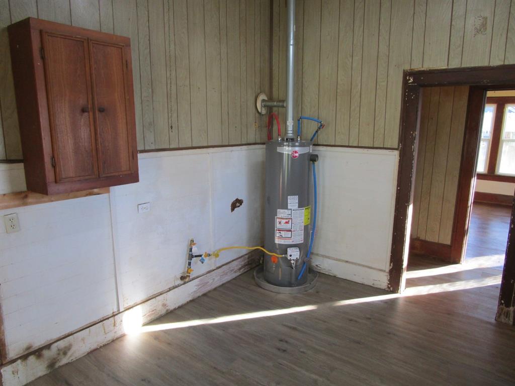 1206 South Main Street Quanah, TX 79252 - Photo 22 of 22 Utility room featuring water heater