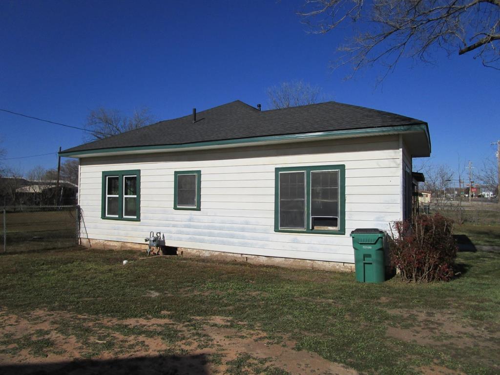 1206 South Main Street Quanah, TX 79252 - Photo 4 of 22 View of home's exterior featuring a lawn and roof with shingles