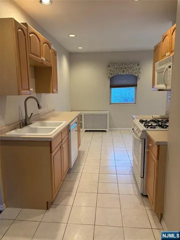 a kitchen with stainless steel appliances a sink a stove top oven a counter space and cabinets