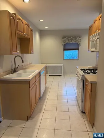 a kitchen with stainless steel appliances a sink a stove top oven a counter space and cabinets