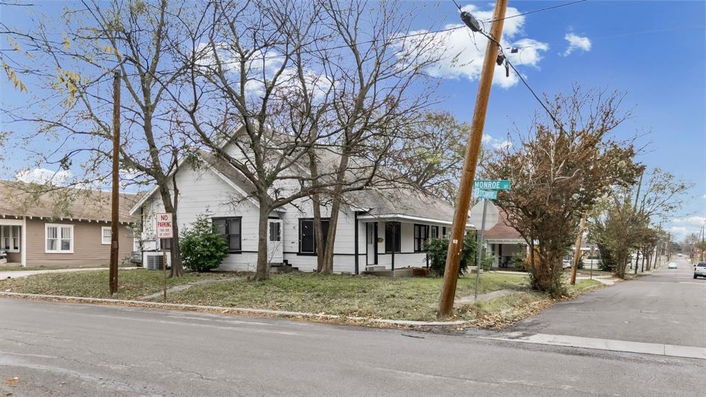 1406 Sycamore Street Commerce, TX 75428 - Photo 22 of 22 a view of a house with a yard and large trees