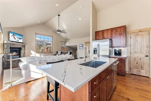 a large kitchen with granite countertop a sink and a refrigerator