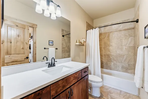 a bathroom with a sink a toilet a mirror and shower