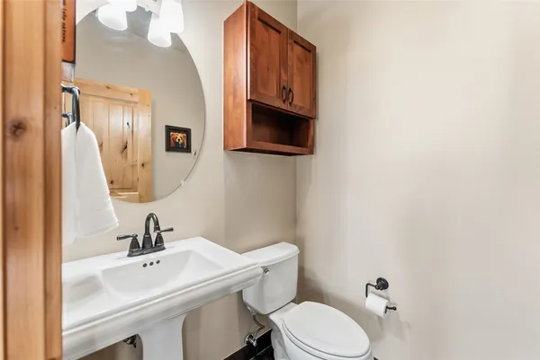a bathroom with a sink a toilet and mirror