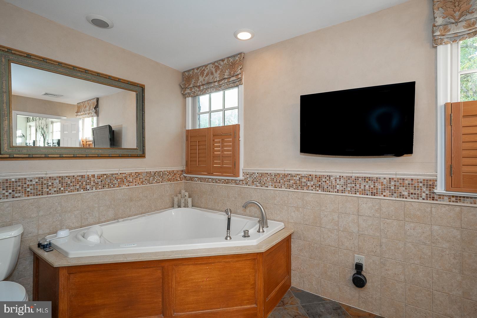 318 Chamounix Road Wayne, PA 19087 - Photo 32 of 55 a bathroom with a tub a window and a flat screen tv