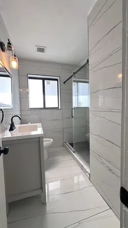 a bathroom with a toilet sink and mirror