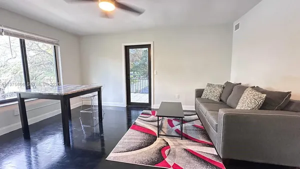 a living room with furniture and a wooden floor